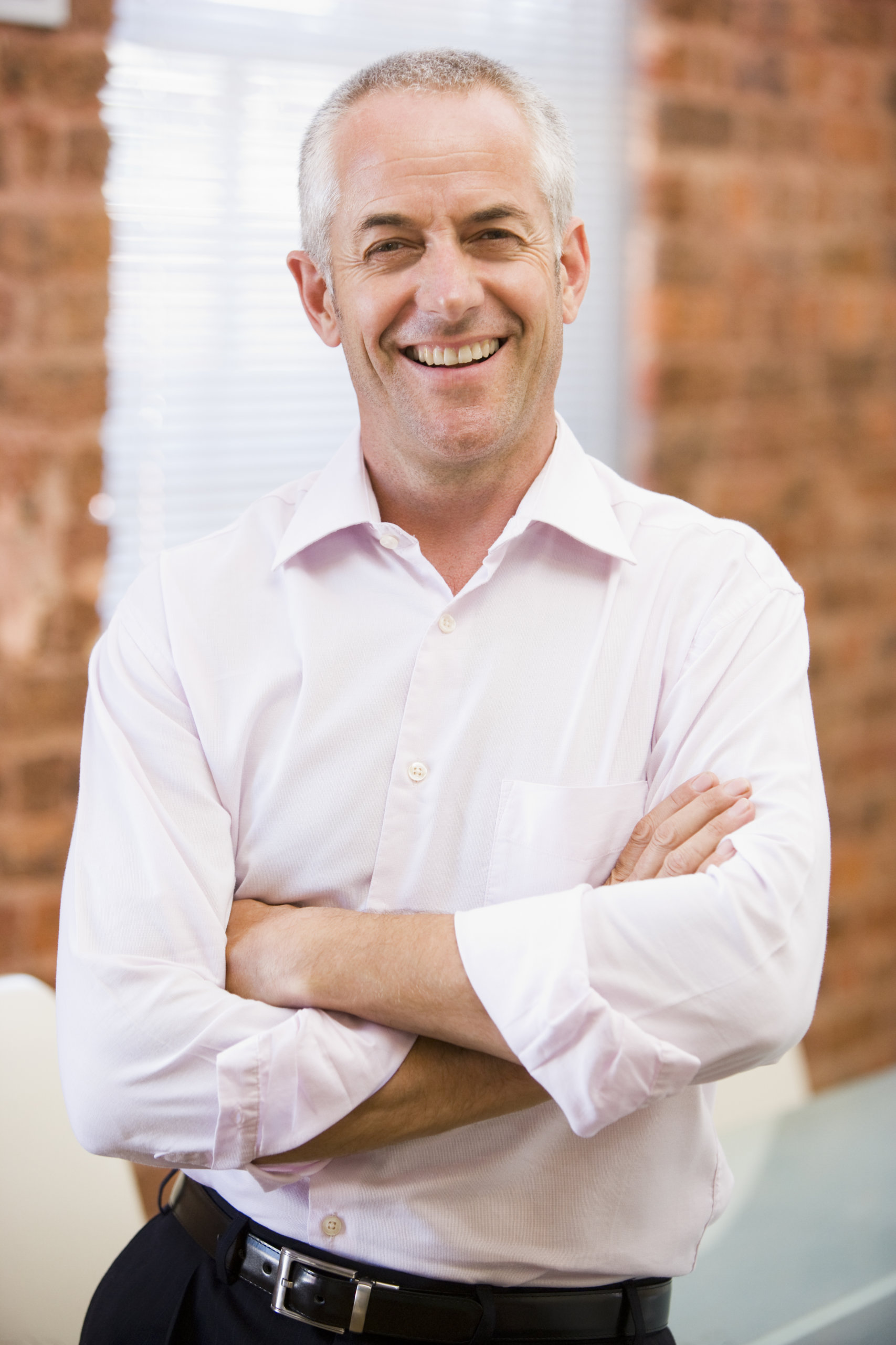 Businessman standing in office laughing